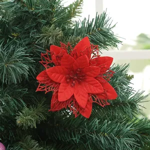 Primo piano di un fiore di poinsettia artificiale rosso con glitter sull'albero