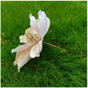 Gros plan d'une fleur de magnolia artificielle avec des paillettes dorées pour Noël