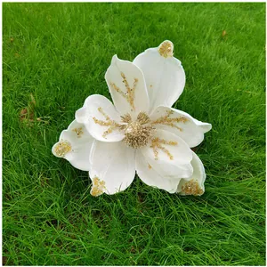 Vue détaillée de fleur de magnolia artificielle blanche avec paillettes dorées pour Noël.