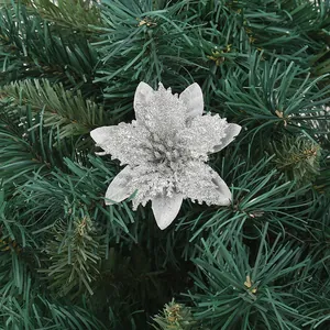 Detailed view of a silver glittery artificial poinsettia flower on a Christmas tree.