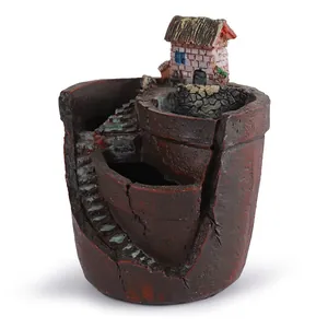 Gedetailleerd aanzicht van een hars plantenbak met miniatuurhuis en een wenteltrap ontwerp