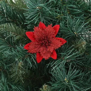 Red glitter artificial Poinsettia flower detail on green Christmas tree branches
