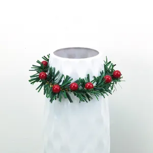 Portatovaglioli a ghirlanda di Natale con bacche rosse su un vaso bianco decorativo