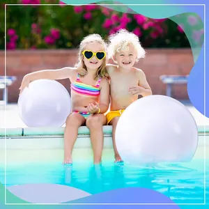Two children playing with large white inflatable beach balls by a bright sunny pool side
