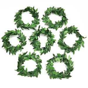 Detailed view showing seven artificial green leaf napkin rings for elegant dining decor