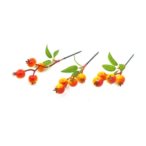 Detail view of artificial foam pomegranate berry branches for Christmas DIY decor
