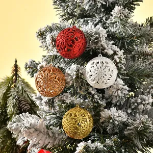 Detailed view of hollow glitter Christmas ornaments hanging on a snowy tree