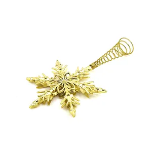 Detail view of a gold-plated snowflake Christmas tree topper with spring base.