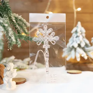 Nahaufnahme eines klaren Acryl-Schneeflocken-Stab-Ornaments in Plastikverpackung
