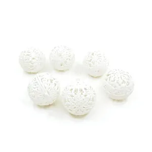 Macro view of white glitter Christmas balls with intricate hollow snowflake patterns