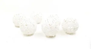 Close-up detail of white glittered hollow snowflake Christmas ornaments on white background.