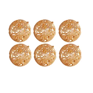 Detail view of six 6cm gold glitter hollow-out Christmas ball ornaments on white background.