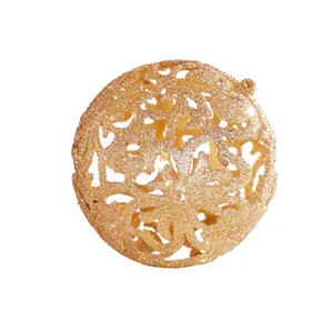 Close-up detail of golden glitter hollow-out Christmas ball ornament with intricate floral patterns