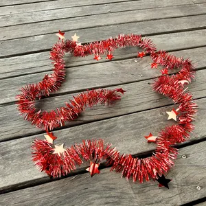 Detail view of shiny red Christmas tinsel garland with metallic star ornaments