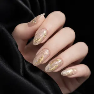 Close-up of elegant gold feather nail stickers on a metallic glitter manicure base