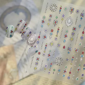 Close-up view of colorful gemstone pattern nail stickers with finished examples on grey nails