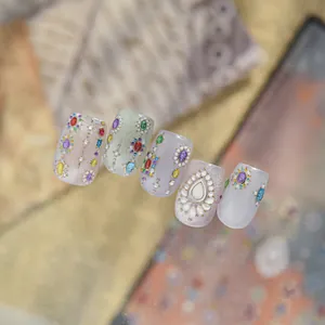 Macro detail shot of light luxury jelly nail stickers with colorful gemstones and bead decor