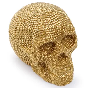 Close-up view of a golden rhinestone studded resin skull mask for Halloween party decor