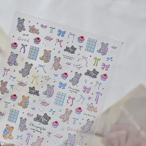 Macro detail of 3D embossed nail stickers with cute bears and bow designs in pastel tones
