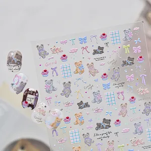 Detailed macro view of 3D embossed nail stickers with cute cartoon bears and bows