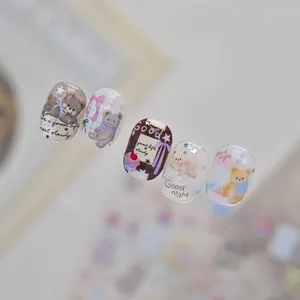 Close-up detail of embossed nail art stickers featuring cute bears and bow designs