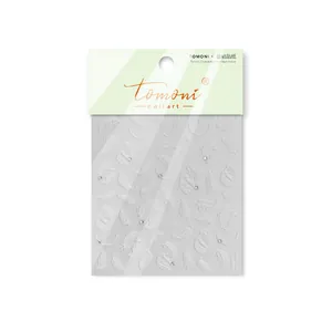 Detail shot of Tomoni white embossed feather nail stickers with crystal diamond accents