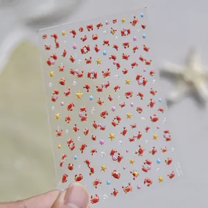 Gros plan de stickers 3D pour ongles avec de mignons crabes orange et des étoiles.