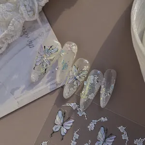 Macro view of iridescent butterfly and white floral nail art decals on clear nails