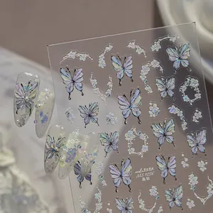 Detailed view of iridescent 3D butterfly nail art stickers with floral accents.