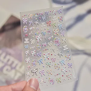 Close-up detail of 3D embossed nail stickers with colorful bows and cute text designs.