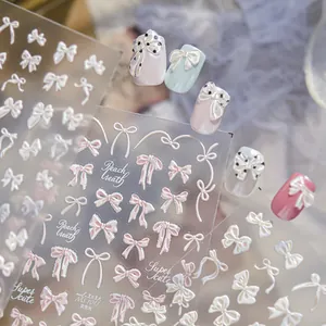 Detalle de pegatinas 3D para uñas con lazos, acabado de brillo nacarado y cintas