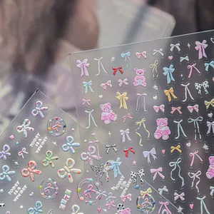 Macro view of sweet 3D embossed nail art stickers with bows, bears, and cute motifs.
