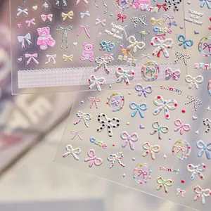 Macro view of 3D relief nail stickers featuring colorful bows and cute bear motifs.