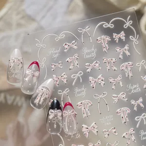 Vista detallada de pegatinas de uñas con lazos 3D y lunares con brillo de nácar