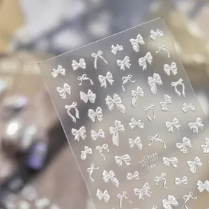 Vista macro detallada de pegatinas de uñas con lazo y brillo de concha en relieve 5D con varios diseños