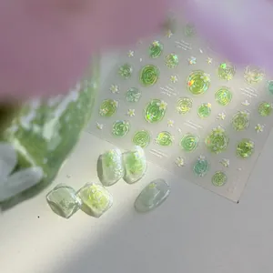 Close-up of translucent green jelly nail stickers with iridescent shell light floral patterns