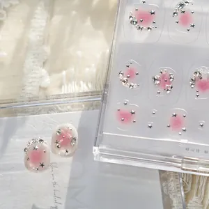 Gros plan de strass pour ongles fraise rose avec étoiles et perles argentées