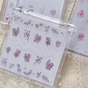 Gros plan de charms nail art TOMONI avec cœurs, clés et ailes métalliques argentés