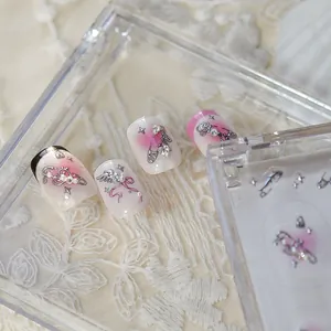 Vue macro détaillée du nail art dégradé rose avec des breloques de luxe en strass coeur et noeud