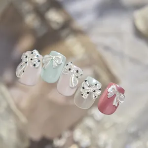 Detalle de pegatinas de lazos 3D para uñas con un elegante brillo nacarado e iridiscente