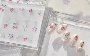 Vue détaillée des breloques nail art 3D fraise et fruits sur faux ongles roses