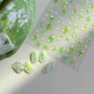 Detail view of green jelly shell nail stickers with floral patterns and sunlit texture