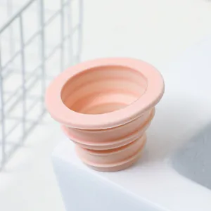 Detail of pink collapsible silicone drain seal plug for kitchen sink and washing machine pipe.