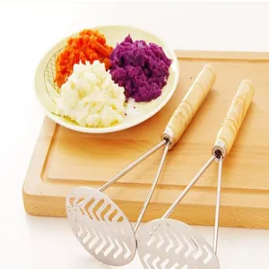 Stainless steel potato masher detail with wooden handle and mashed food scene view.