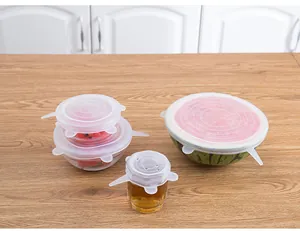 Detail view of transparent silicone stretch lids sealing cups, bowls, and fruit securely.