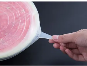 Silicone stretch lid detail view showing elasticity and usage on fruit, flexible food cover.
