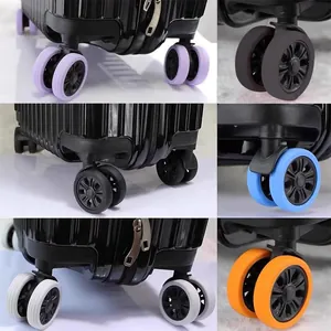 Vue rapprochée détaillée de housses de roue de valise en silicone coloré installées.