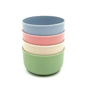 Detailed view of colorful wheat straw bowls stacked together, showing natural speckled texture.