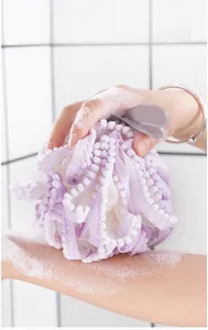 Grand pouf de bain violet et blanc éponge filet douce pour la douche et le corps.