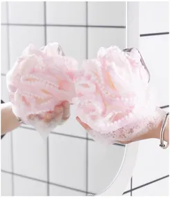 Vue detaillee de l'eponge de douche rose douce avec decoration de perles pour le soin du corps.